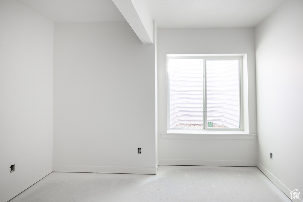 Empty room with baseboards and concrete floors
