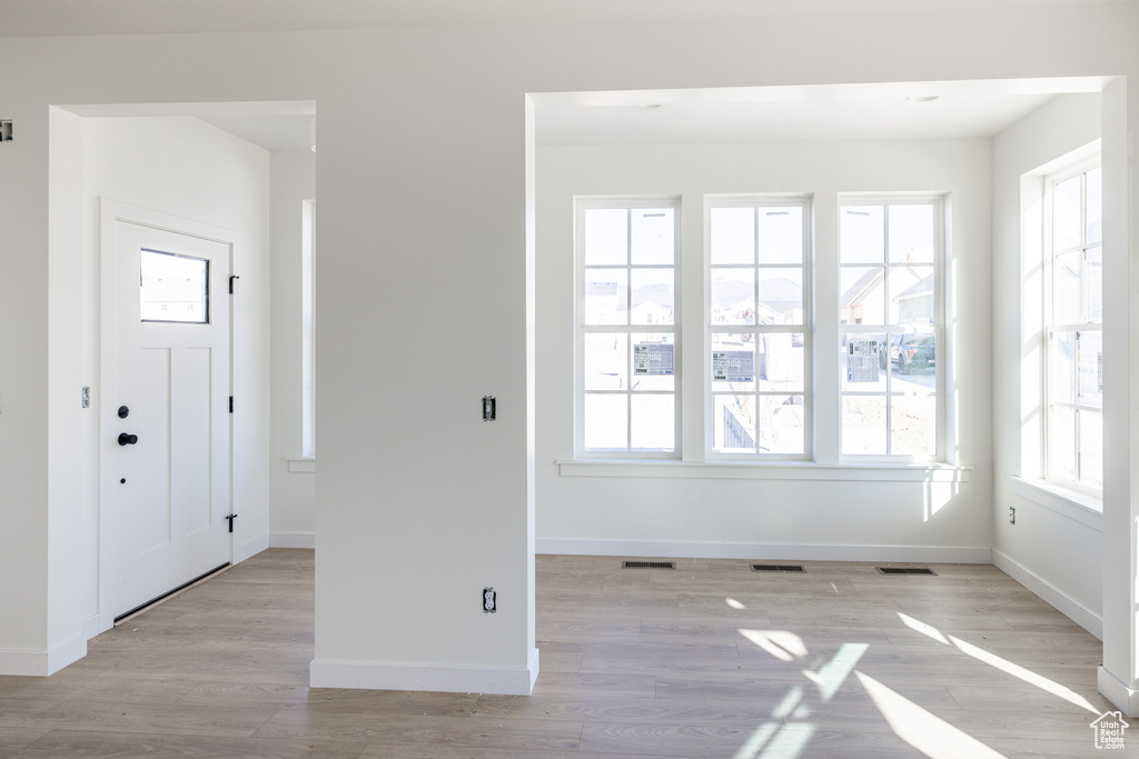 Foyer featuring light wood-type flooring, visible vents, and baseboards