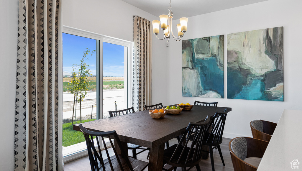 Dining room with wood finished floors, baseboards, and a notable chandelier