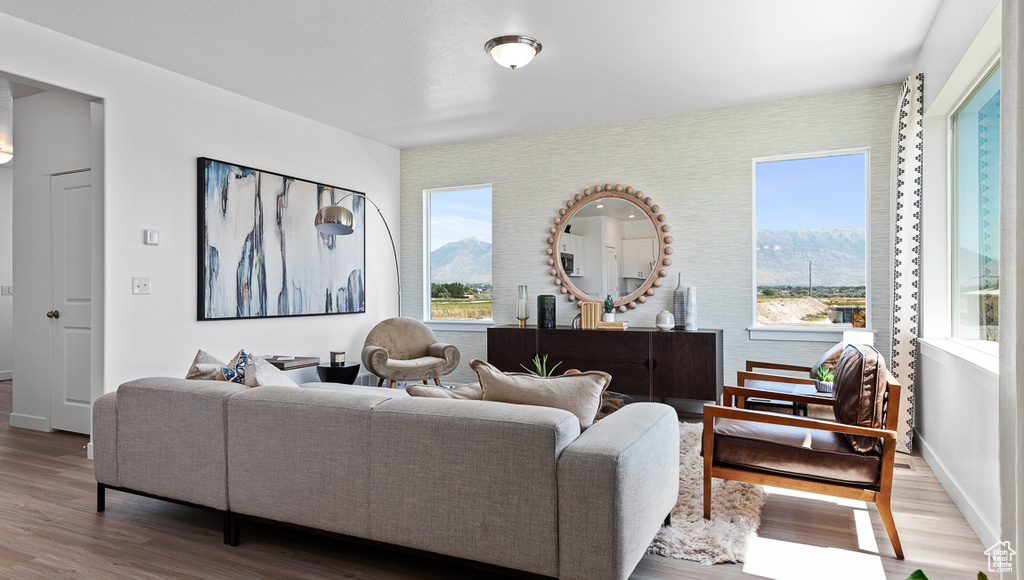 Living area with a mountain view, wood finished floors, and baseboards