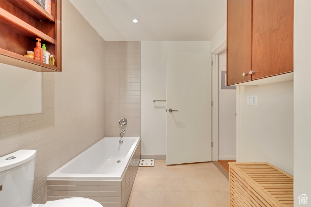 Full bathroom featuring tile patterned floors, toilet, tiled tub, and recessed lighting