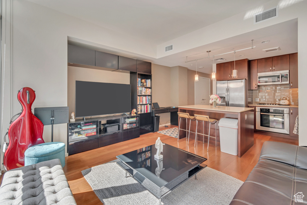 Living room with light wood-style floors and visible vents