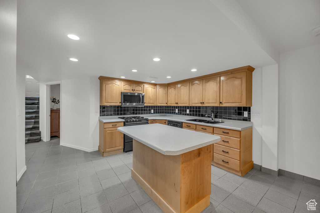 Kitchen featuring black appliances, baseboards, a sink, light countertops, and recessed lighting