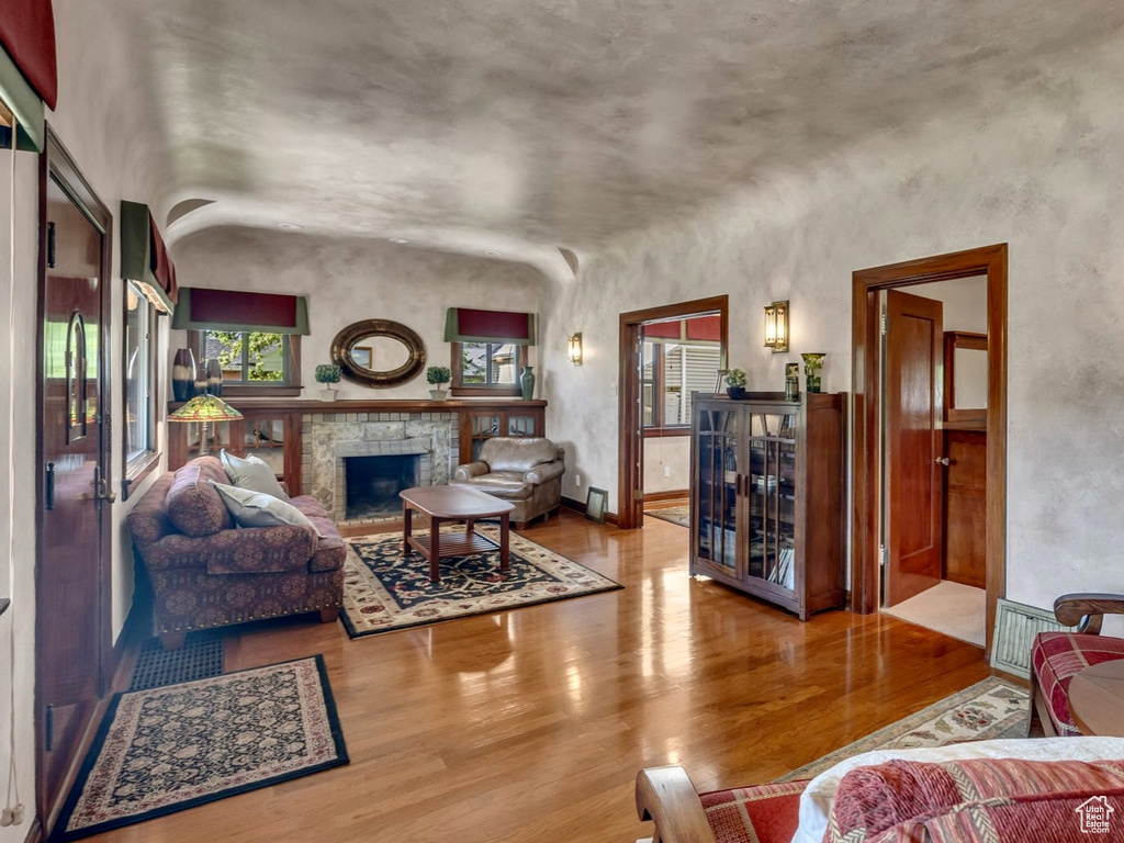 Living room with wood finished floors, a fireplace, and baseboards