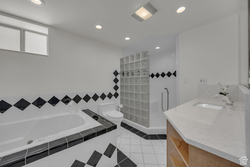 Full bathroom with tile patterned floors, toilet, walk in shower, recessed lighting, and a garden tub