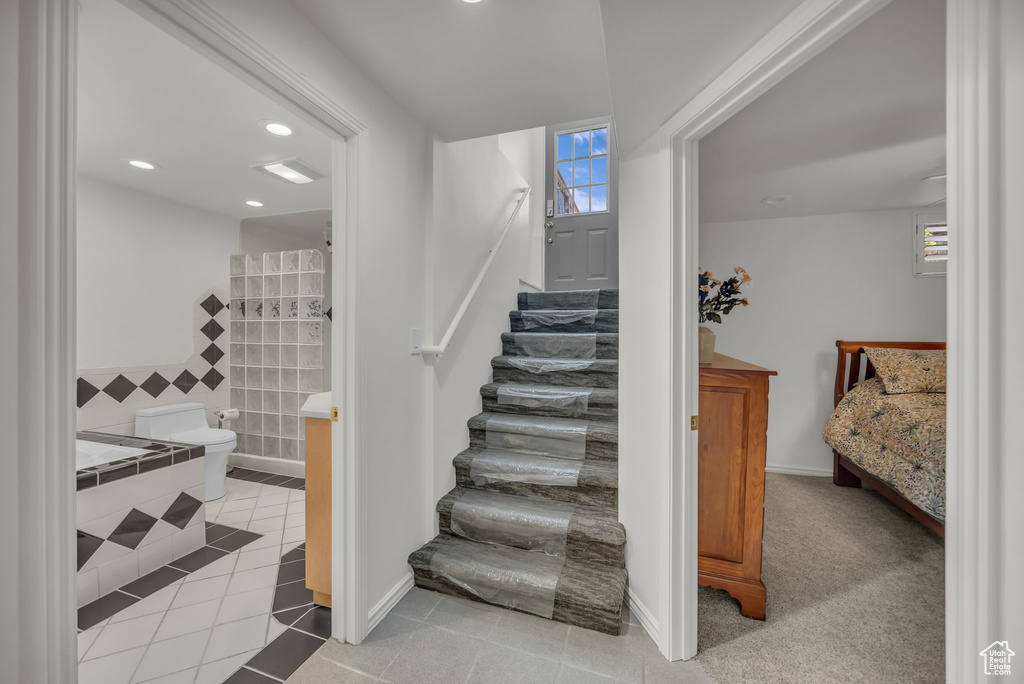 Stairway with tile patterned floors, recessed lighting, and baseboards