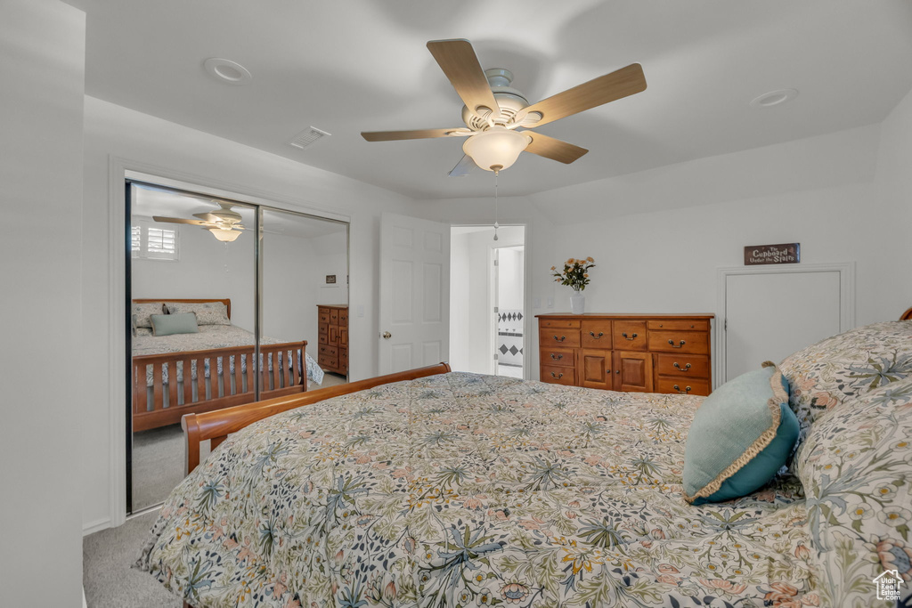 Carpeted bedroom with a closet, ceiling fan, and baseboards
