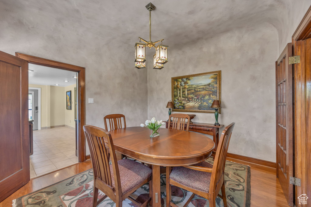 Dining space featuring light wood-type flooring, baseboards, and a chandelier
