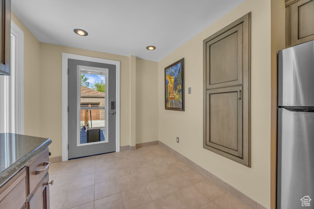 Entryway with light tile patterned flooring, baseboards, and recessed lighting