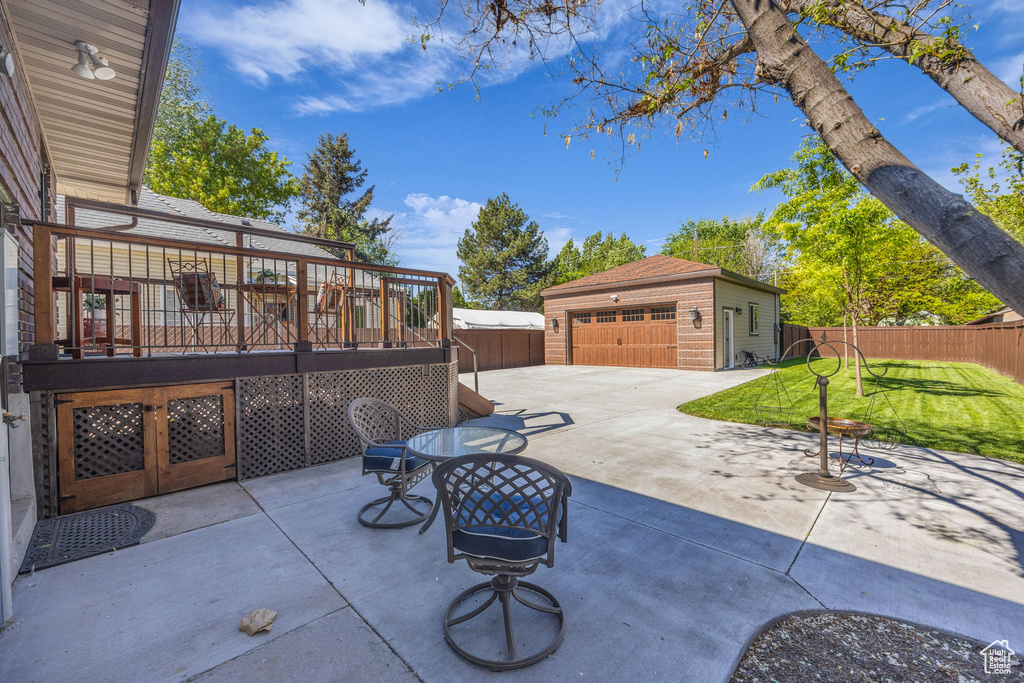 View of patio with an outdoor structure, a wooden deck, and a detached garage