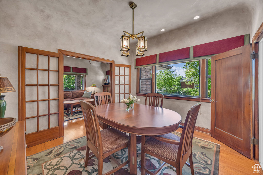 Dining space with light wood-style floors, healthy amount of natural light, and a chandelier