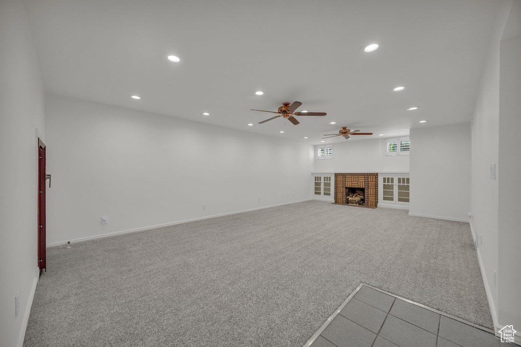 Unfurnished living room featuring recessed lighting, a ceiling fan, carpet flooring, baseboards, and a fireplace with flush hearth