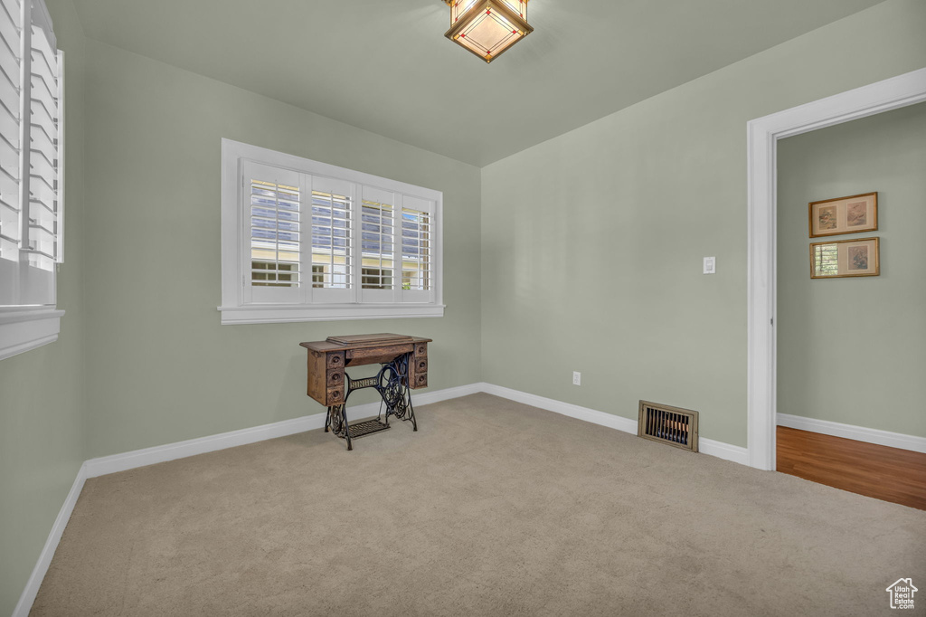 Spare room featuring carpet floors and baseboards