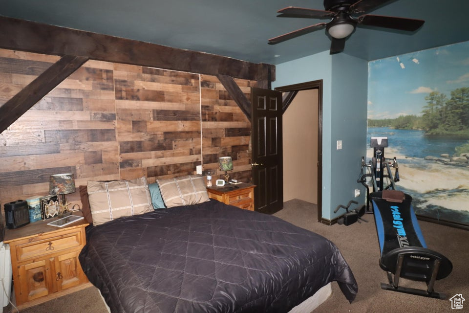 Carpeted bedroom featuring wood walls