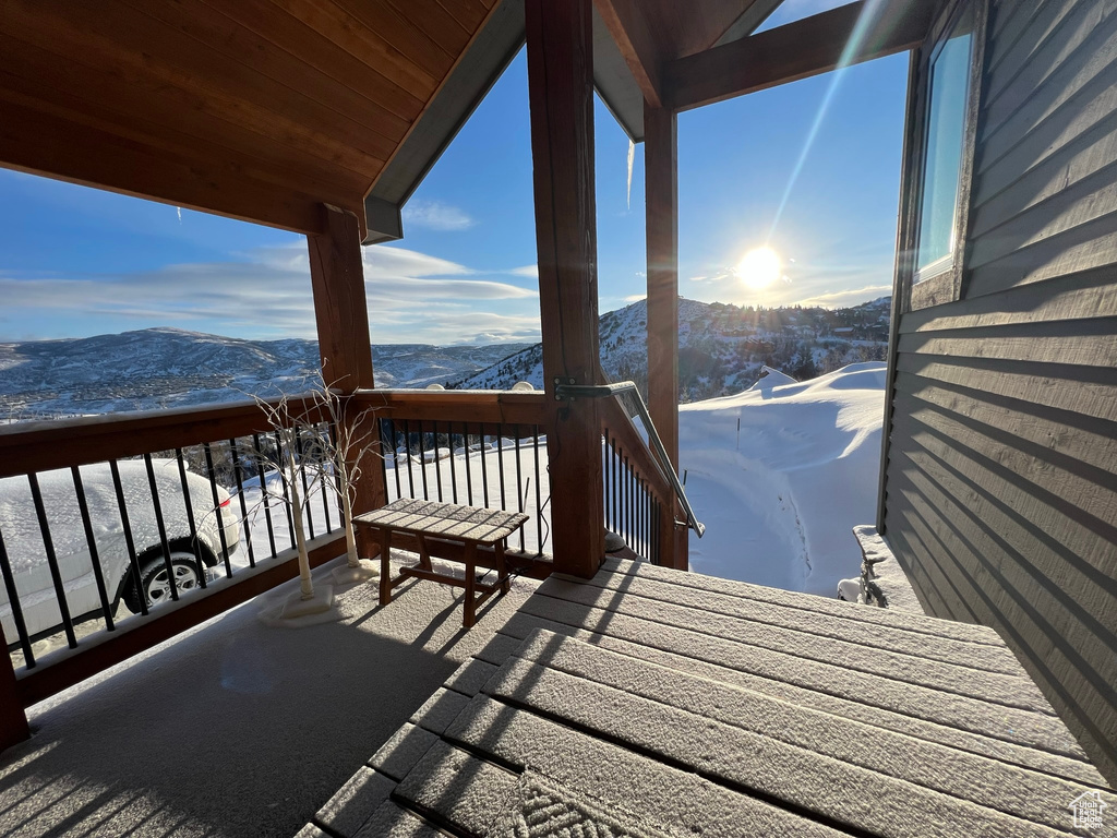 Snow covered deck featuring a mountain view