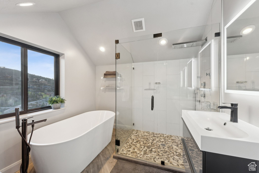 Bathroom with lofted ceiling, vanity, visible vents, a shower stall, and a freestanding tub