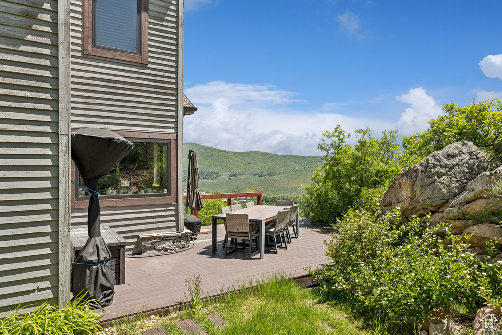 View of patio / terrace featuring outdoor dining space and a deck with mountain view