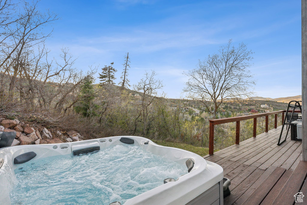 Wooden deck featuring a hot tub and a mountain view
