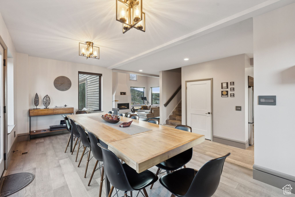 Dining area with recessed lighting, light wood-type flooring, a chandelier, and stairs