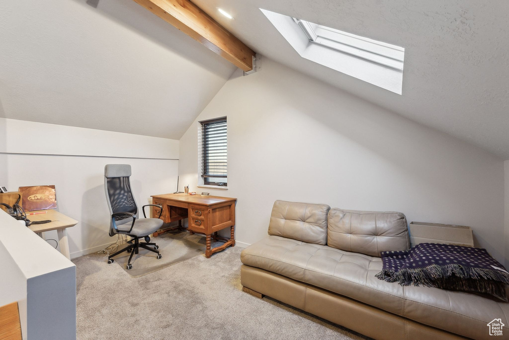 Home office with baseboards, carpet flooring, and vaulted ceiling with skylight