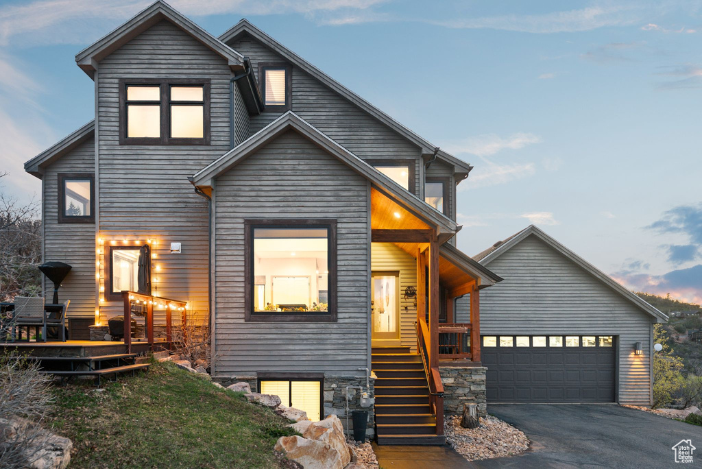 Contemporary home with a porch, aphalt driveway, and stairway