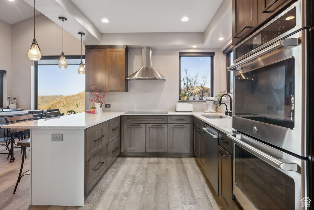 Kitchen with a peninsula, light wood-type flooring, a sink, and a breakfast bar area