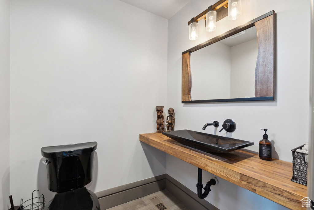 Bathroom featuring baseboards, visible vents, and a sink
