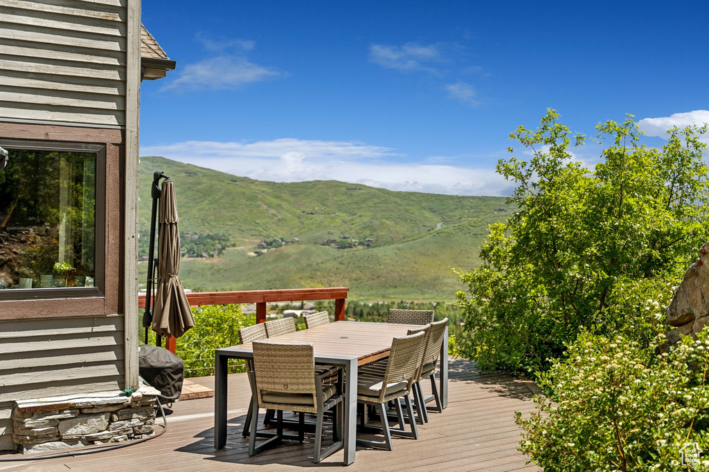 Wooden terrace featuring outdoor dining area and a mountain view