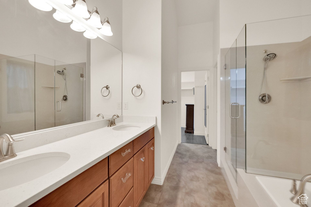 Full bath with a sink, a shower stall, and double vanity