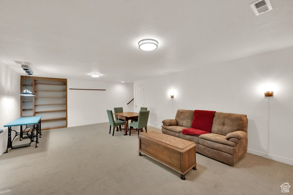 Living room featuring baseboards, light carpet, and visible vents