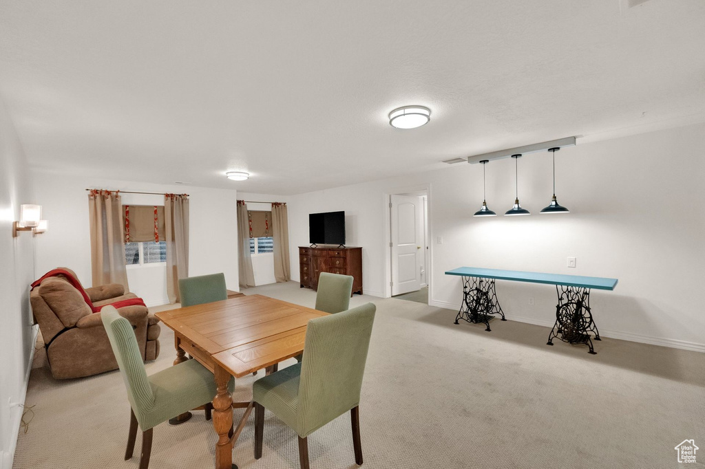 Dining room with baseboards and light colored carpet