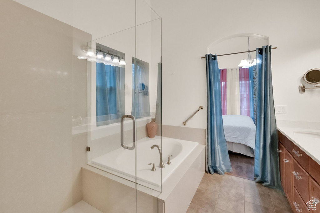 Ensuite bathroom featuring tile patterned flooring, vanity, ensuite bathroom, an enclosed shower, and a bath