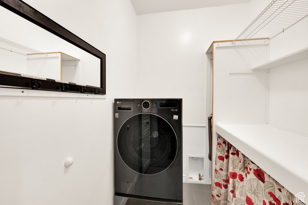 Clothes washing area featuring washer / clothes dryer and laundry area