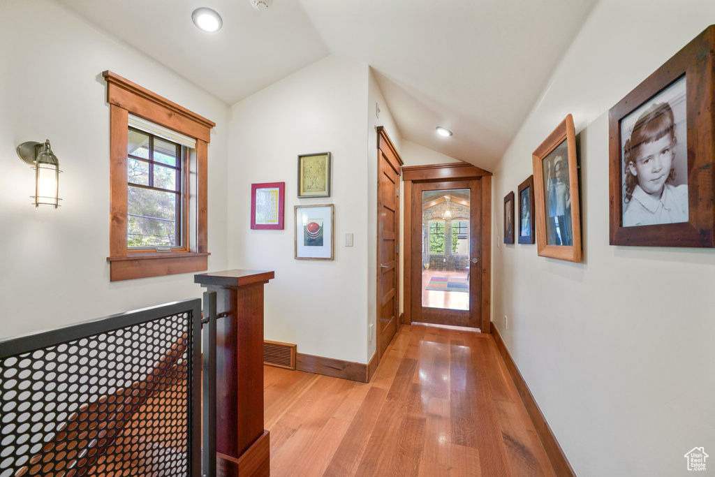Hallway with lofted ceiling, recessed lighting, baseboards, light wood finished floors, and visible vents