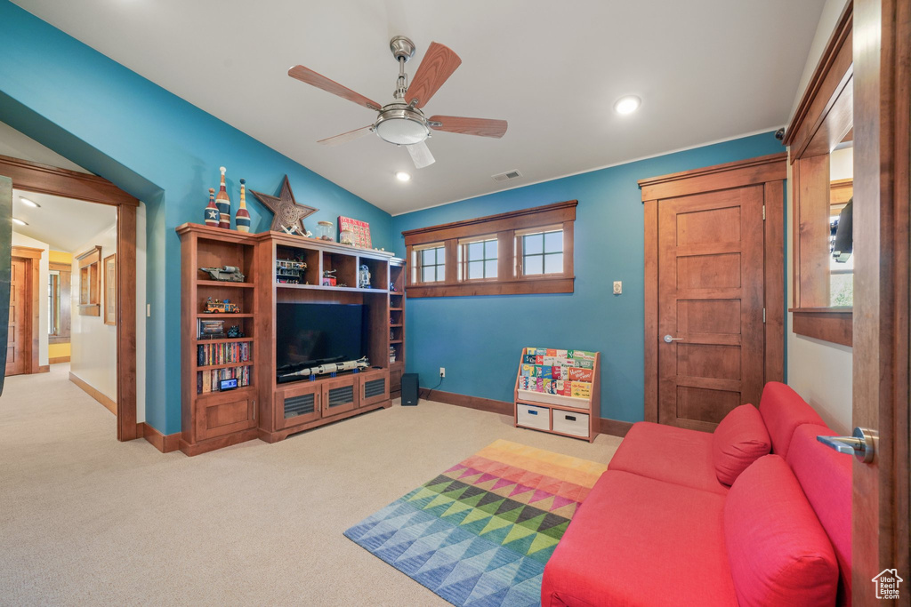 Carpeted living area featuring baseboards, a ceiling fan, and recessed lighting