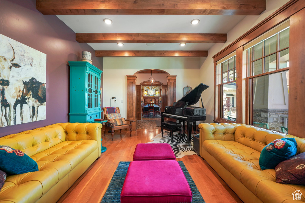 Living room with recessed lighting, decorative columns, arched walkways, and wood finished floors