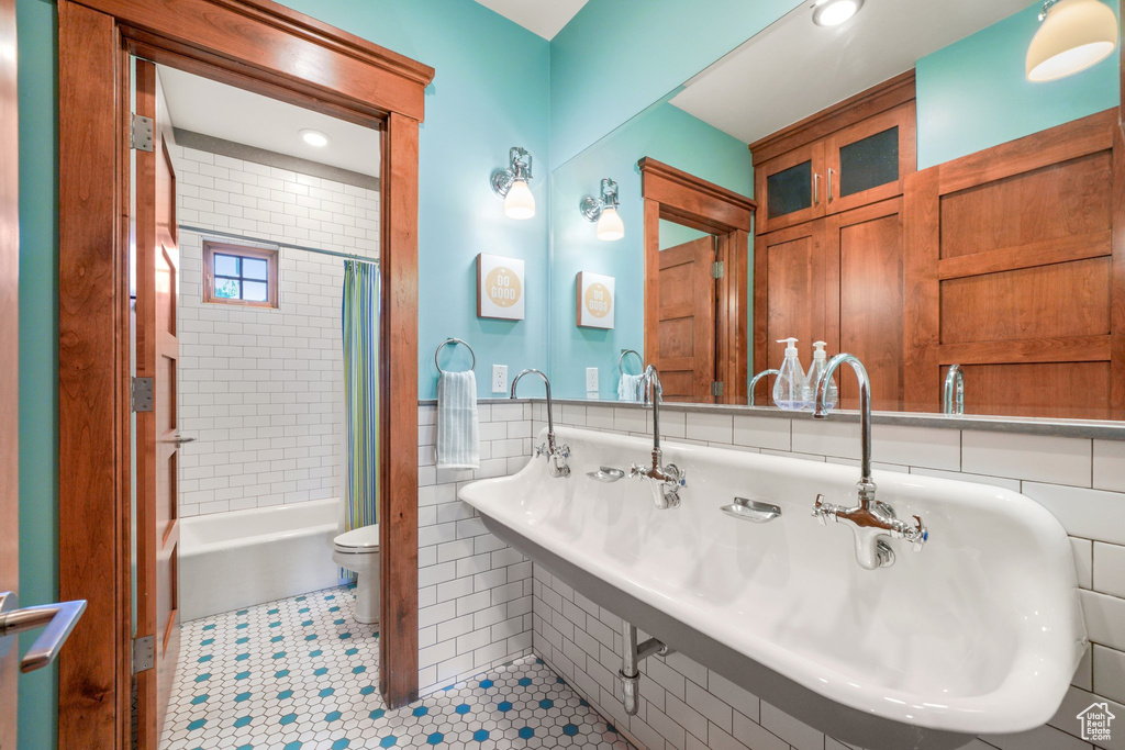 Full bathroom with shower / tub combo with curtain, tile patterned flooring, toilet, and recessed lighting