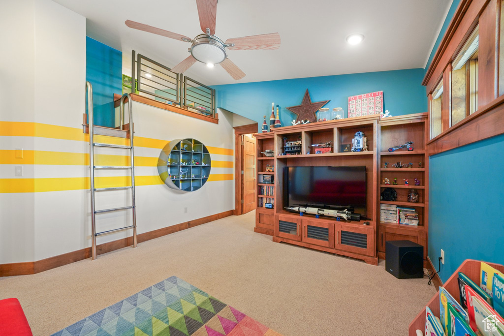 Carpeted living area with ceiling fan, baseboards, and recessed lighting