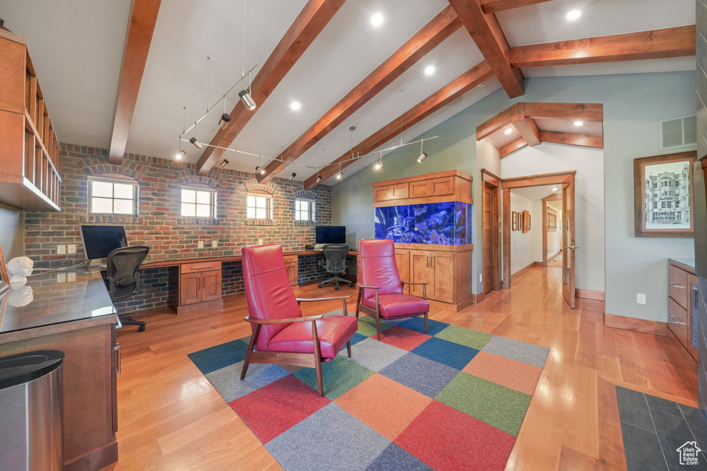 Living room with light wood-type flooring, brick wall, an office area, and baseboards