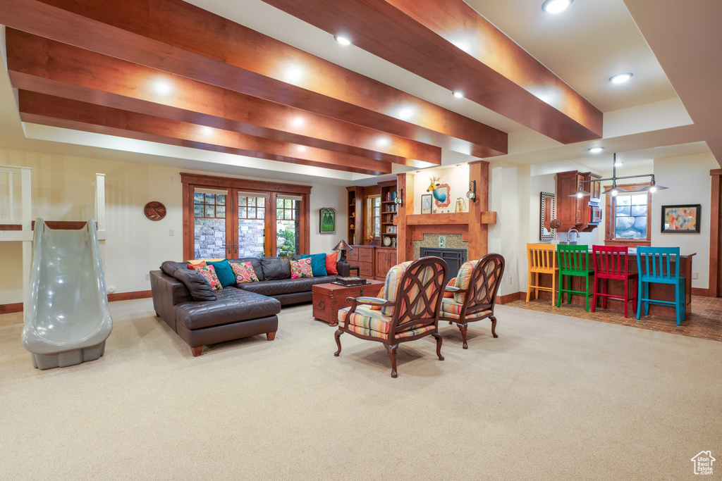 Carpeted living room with a tiled fireplace, baseboards, and recessed lighting