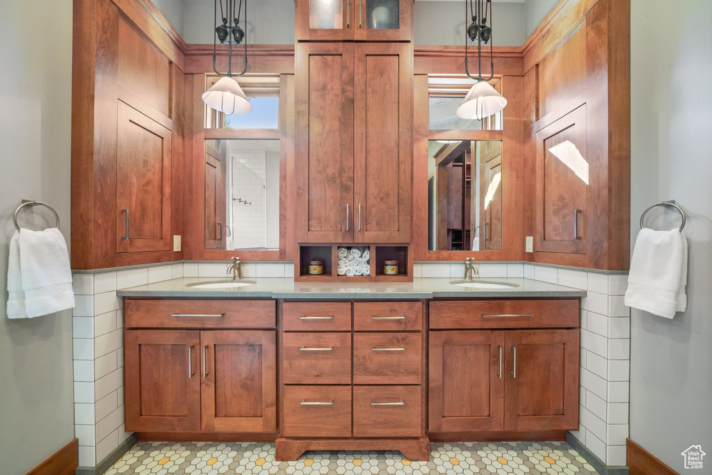 Bathroom featuring double vanity, baseboards, and a sink