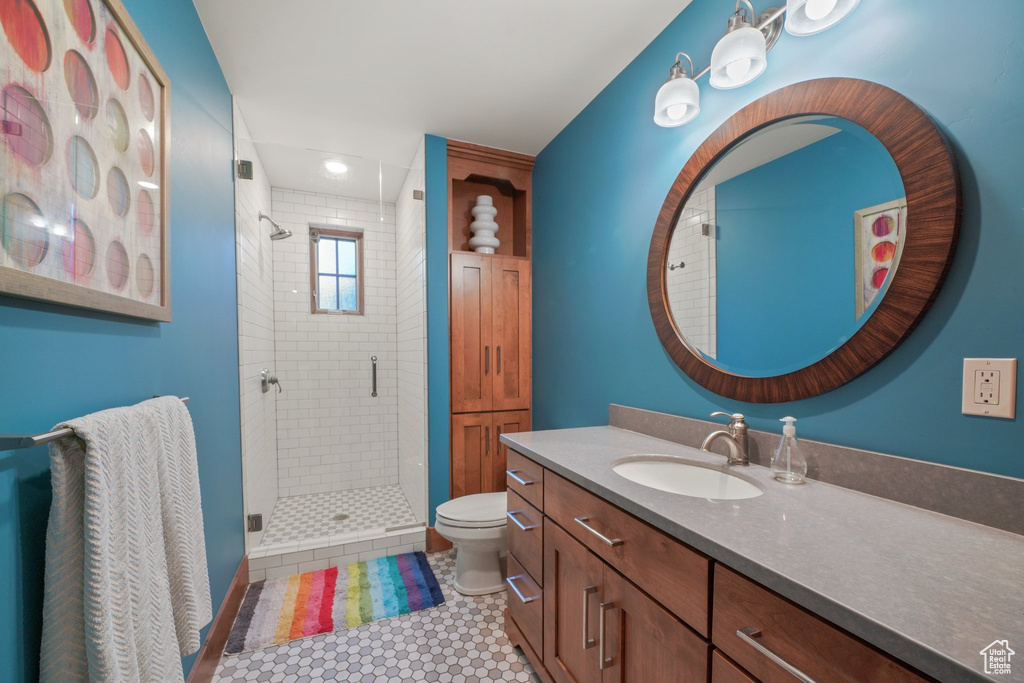 Full bathroom with a stall shower, toilet, and vanity