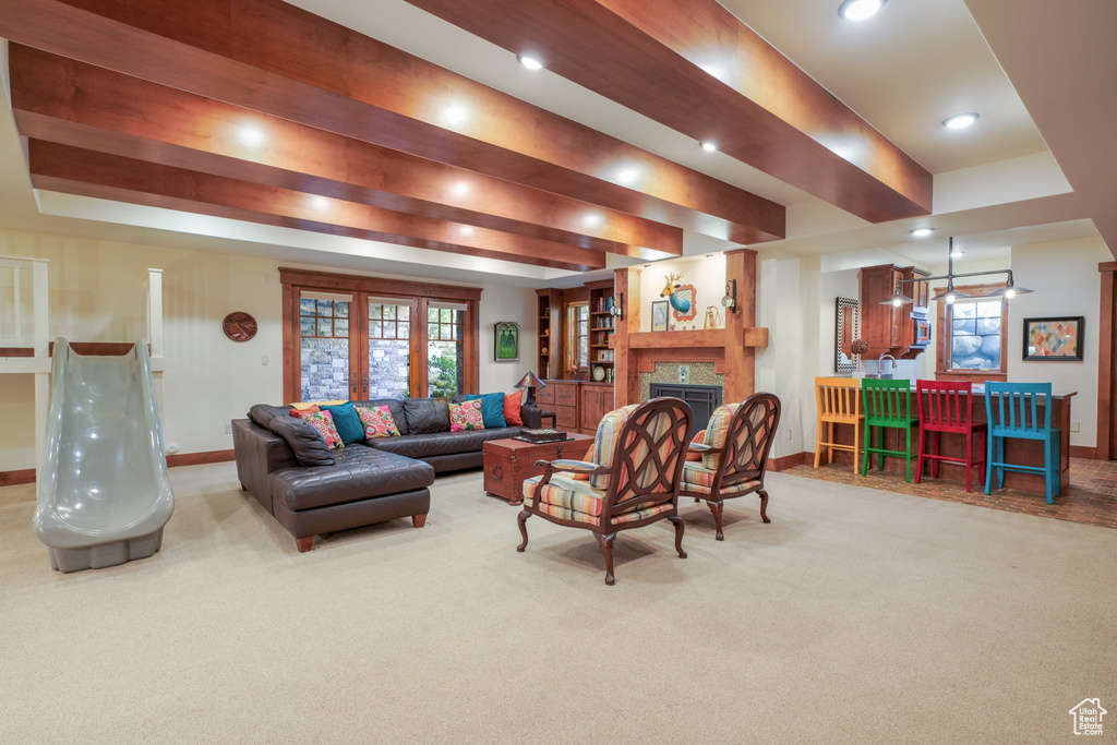 Living area with carpet, baseboards, a tiled fireplace, and recessed lighting