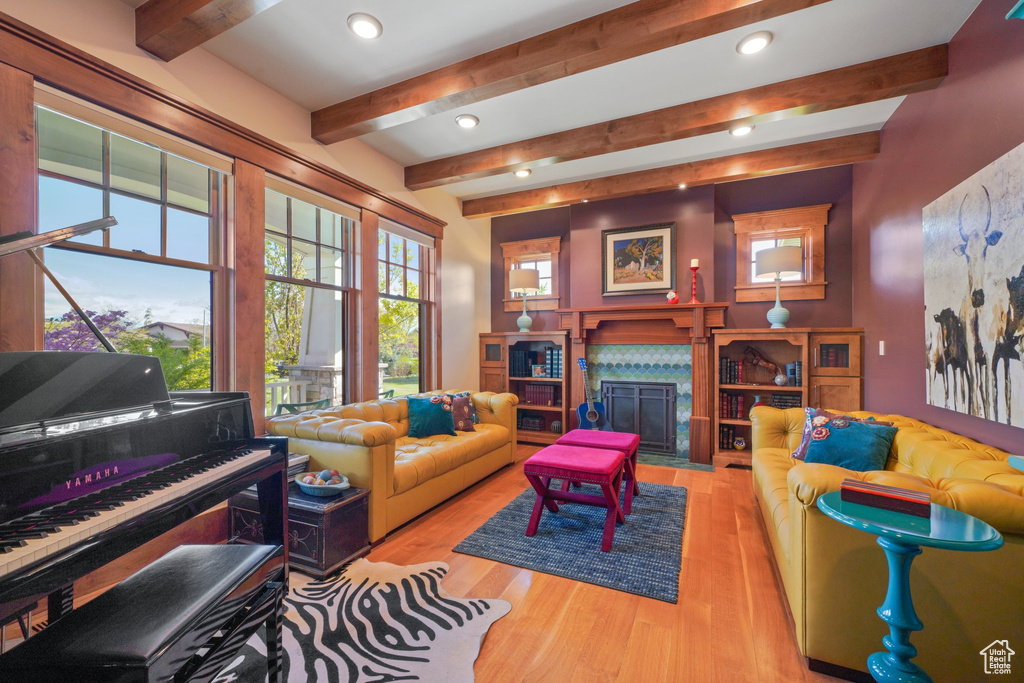 Living room featuring recessed lighting, wood finished floors, beamed ceiling, and a high end fireplace
