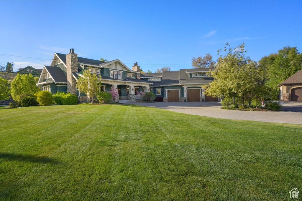 View of front of house with stone siding, a chimney, and a front yard