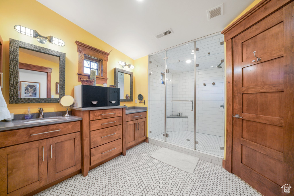 Bathroom featuring a stall shower, vanity, and visible vents