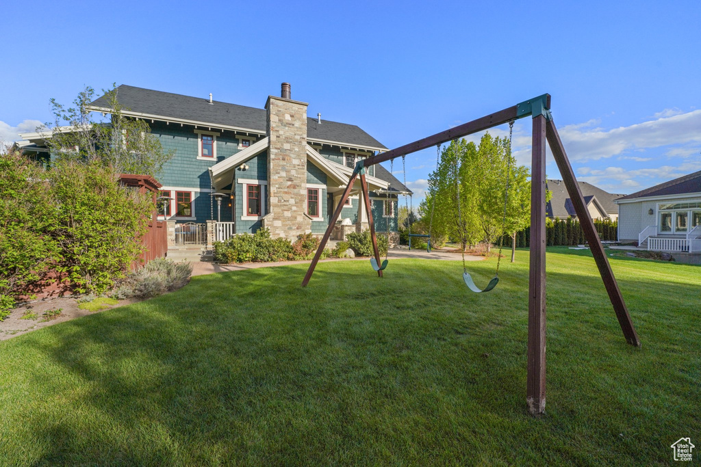 Rear view of house featuring a yard and a chimney