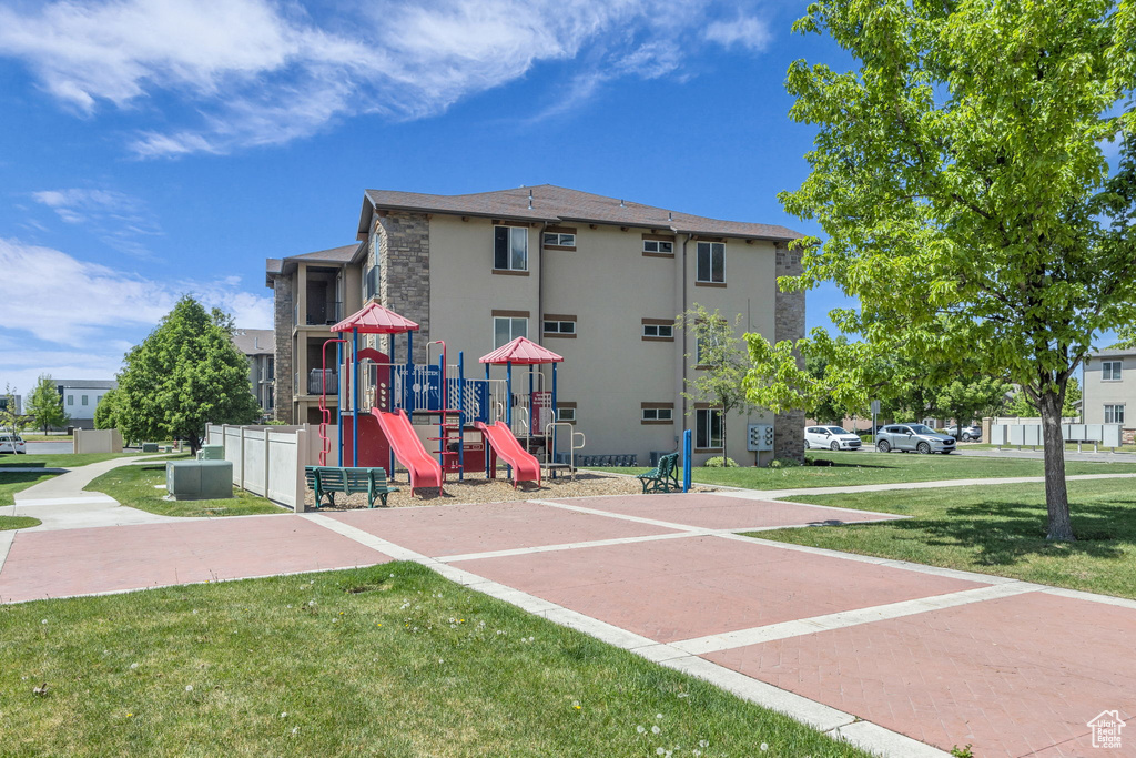 Exterior space with a yard, stone siding, stucco siding, and playground community