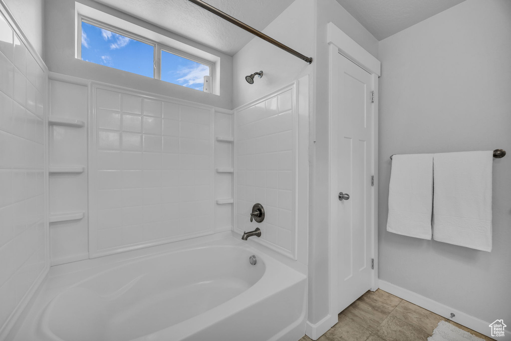 Full bath featuring baseboards and  shower combination
