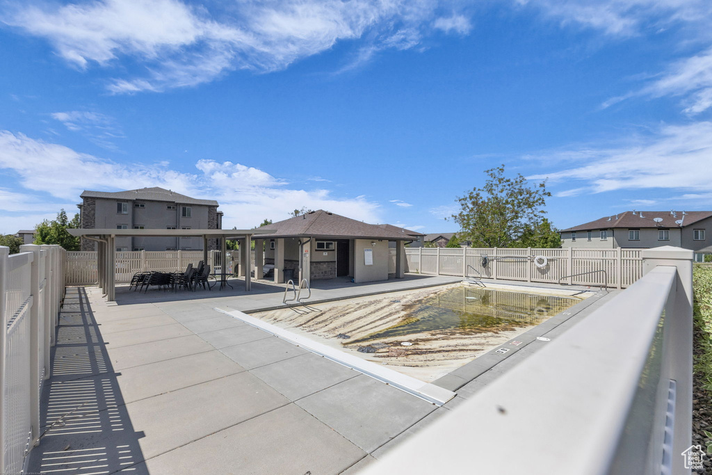 Rear view of property with a patio area, outdoor dining space, a community pool, and a fenced backyard